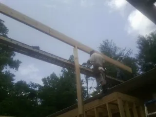 Carpenter setting a ridge beam over a new addition frame — Ice Dam Removal by Roofing Brothers in Gravity