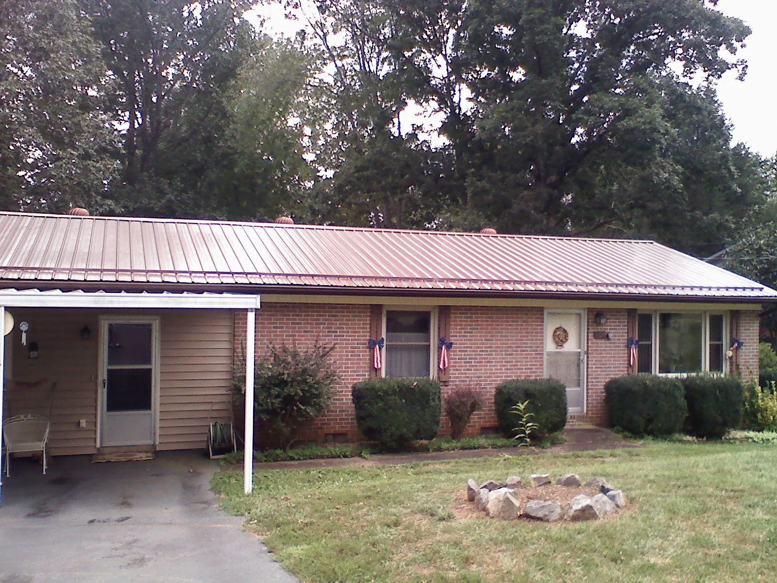 Bronze metal roof and carport on a brick ranch home — Roof Repair work by our crew in Gravity